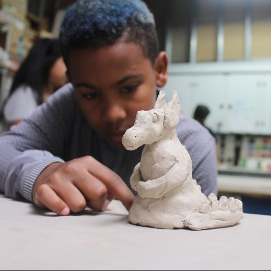 Erick Dawkins finishes his clay dragon in Clay Critters.